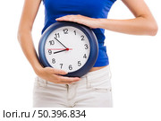 Causal young woman holding a clock, isolated over a white background. Стоковое фото, агентство Ingram Publishing / Фотобанк Лори