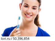 Beautiful woman with a great smile holding toothbrush, isolated over a white background. Стоковое фото, агентство Ingram Publishing / Фотобанк Лори
