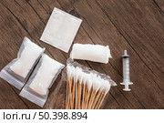 medical cotton gauze bandage syringe pack cotton swab wooden table. Стоковое фото, агентство Ingram Publishing / Фотобанк Лори