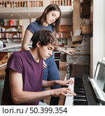 teen boy playing piano girlfriend. Стоковое фото, агентство Ingram Publishing / Фотобанк Лори