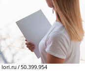 OLYMPUS DIGITAL CAMERA. high view woman holding mock up magazine. Стоковое фото, агентство Ingram Publishing / Фотобанк Лори