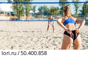 back view woman signaling teammate with hands while playing volleyball. Стоковое фото, агентство Ingram Publishing / Фотобанк Лори