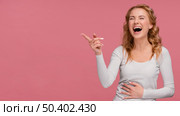 portrait female laughs pointing copy space. Стоковое фото, агентство Ingram Publishing / Фотобанк Лори