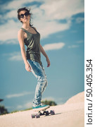 Young woman down the road with a skateboard. Стоковое фото, агентство Ingram Publishing / Фотобанк Лори