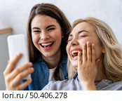 front view happy women smiling taking selfie. Стоковое фото, агентство Ingram Publishing / Фотобанк Лори