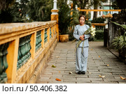 front view woman holding bouquet flowers temple. Стоковое фото, агентство Ingram Publishing / Фотобанк Лори