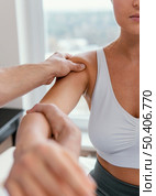 male osteopathic therapist checking female patient s shoulder. Стоковое фото, агентство Ingram Publishing / Фотобанк Лори