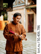 man holding bundle incense temple. Стоковое фото, агентство Ingram Publishing / Фотобанк Лори
