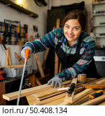 female cutting wood plank 2. Стоковое фото, агентство Ingram Publishing / Фотобанк Лори