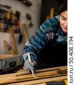 female workshop brushing dust from wood planks. Стоковое фото, агентство Ingram Publishing / Фотобанк Лори