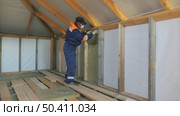 Insulation of a frame house with mineral wool. Cutting, fitting, laying insulation. Construction works. Стоковое видео, видеограф Константин Мерцалов / Фотобанк Лори