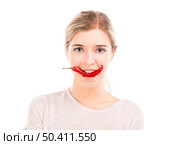 Beautiful girl biting a red chilli pepper, isolated over a white background. Стоковое фото, агентство Ingram Publishing / Фотобанк Лори