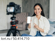pretty woman vlogging pointing her phone. Стоковое фото, агентство Ingram Publishing / Фотобанк Лори