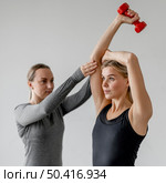 workout with personal trainer dumbbells medium shot. Стоковое фото, агентство Ingram Publishing / Фотобанк Лори