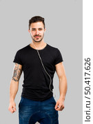 Beautiful latin man listen music over a gray background. Стоковое фото, агентство Ingram Publishing / Фотобанк Лори
