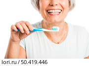 Portrait of a happy old woman brushing her teeth. Стоковое фото, агентство Ingram Publishing / Фотобанк Лори