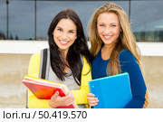 Two happy and beautiful teenage students in the school . Стоковое фото, агентство Ingram Publishing / Фотобанк Лори