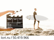 Businessman in front of a clapboard holding is surfboard. Concept about a man starting a new life. Стоковое фото, агентство Ingram Publishing / Фотобанк Лори
