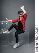 amazed young woman touching air during vr experience. Стоковое фото, агентство Ingram Publishing / Фотобанк Лори
