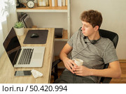 high angle teenager boy doing online classes. Стоковое фото, агентство Ingram Publishing / Фотобанк Лори