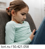 little girl playing smartphone indoors. Стоковое фото, агентство Ingram Publishing / Фотобанк Лори