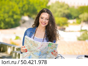 A young and beautiful female tourist searching a place on the map. Стоковое фото, агентство Ingram Publishing / Фотобанк Лори