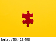 elevated view red jigsaw puzzle piece yellow backdrop. Стоковое фото, агентство Ingram Publishing / Фотобанк Лори