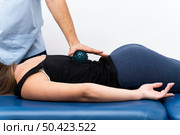 female patient getting massage from physiotherapist with ball. Стоковое фото, агентство Ingram Publishing / Фотобанк Лори
