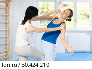 Woman is practicing self defence moves in pair with her female trainer at gym. Стоковое фото, фотограф Яков Филимонов / Фотобанк Лори