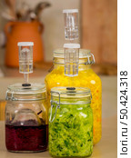 Preparing fermented preserved vegetables. Jars of cabbage kimchi and sauerkraut sour cabbage. . Стоковое фото, агентство Ingram Publishing / Фотобанк Лори