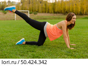 An attractive woman exercising outdoor on a soccer field. Стоковое фото, агентство Ingram Publishing / Фотобанк Лори