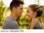 Portrait of a happy young couple in love and giving a kiss. Стоковое фото, агентство Ingram Publishing / Фотобанк Лори