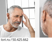 close up man experiencing headache. Стоковое фото, агентство Ingram Publishing / Фотобанк Лори