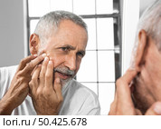 close up man popping pimple. Стоковое фото, агентство Ingram Publishing / Фотобанк Лори