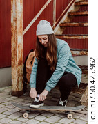 female skater sitting her skateboarding outdoors 2. Стоковое фото, агентство Ingram Publishing / Фотобанк Лори