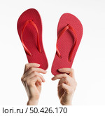 front view hands holding flip flops. Стоковое фото, агентство Ingram Publishing / Фотобанк Лори