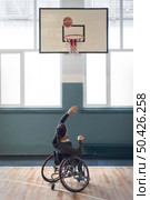 full shot disabled man throwing ball. Стоковое фото, агентство Ingram Publishing / Фотобанк Лори