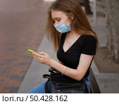 woman with medical mask sitting bench outdoors. Стоковое фото, агентство Ingram Publishing / Фотобанк Лори