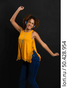 Beautiful African American woman listen  music and dancing. Стоковое фото, агентство Ingram Publishing / Фотобанк Лори