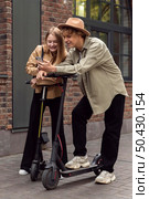couple with electric scooters smartphone city. Стоковое фото, агентство Ingram Publishing / Фотобанк Лори