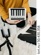 female musician blogger streaming home with smartphone. Стоковое фото, агентство Ingram Publishing / Фотобанк Лори
