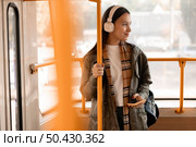 female passenger holding tram pole. Стоковое фото, агентство Ingram Publishing / Фотобанк Лори
