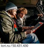 side view couple looking map while road tripping. Стоковое фото, агентство Ingram Publishing / Фотобанк Лори