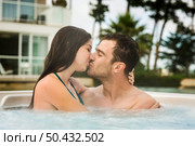 Young couple in a luxury hotel  inside a jacuzzi and kissing. Стоковое фото, агентство Ingram Publishing / Фотобанк Лори