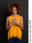 Beautiful African American woman texting a sms. Стоковое фото, агентство Ingram Publishing / Фотобанк Лори