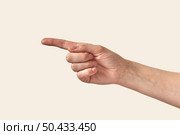 Woman’s hand with one finger or 1, singe, first in finger alphabet sign language isolated on white background. Pointing direction hand on beige.. Female hand showing direction finger, arm on white background. Стоковое фото, агентство Ingram Publishing / Фотобанк Лори