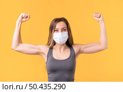 strong woman with medical mask showing her muscles. Стоковое фото, агентство Ingram Publishing / Фотобанк Лори