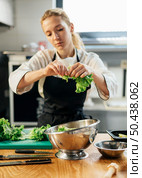 female chef with apron tearing salad bowl. Стоковое фото, агентство Ingram Publishing / Фотобанк Лори