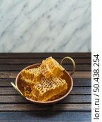 OLYMPUS DIGITAL CAMERA. fresh honey comb pieces copper utensil wooden table. Стоковое фото, агентство Ingram Publishing / Фотобанк Лори
