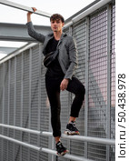 non binary person posing metallic fence. Стоковое фото, агентство Ingram Publishing / Фотобанк Лори